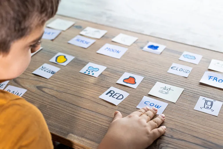 Il bambino sta imparando le parole inglesi dalle carte con parole e immagini
