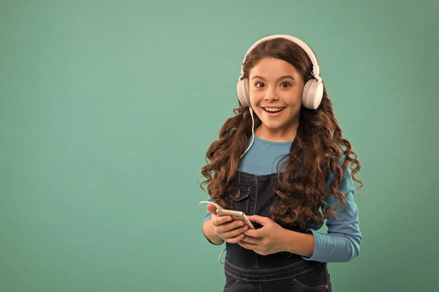 Girl with headphones holding the phone
