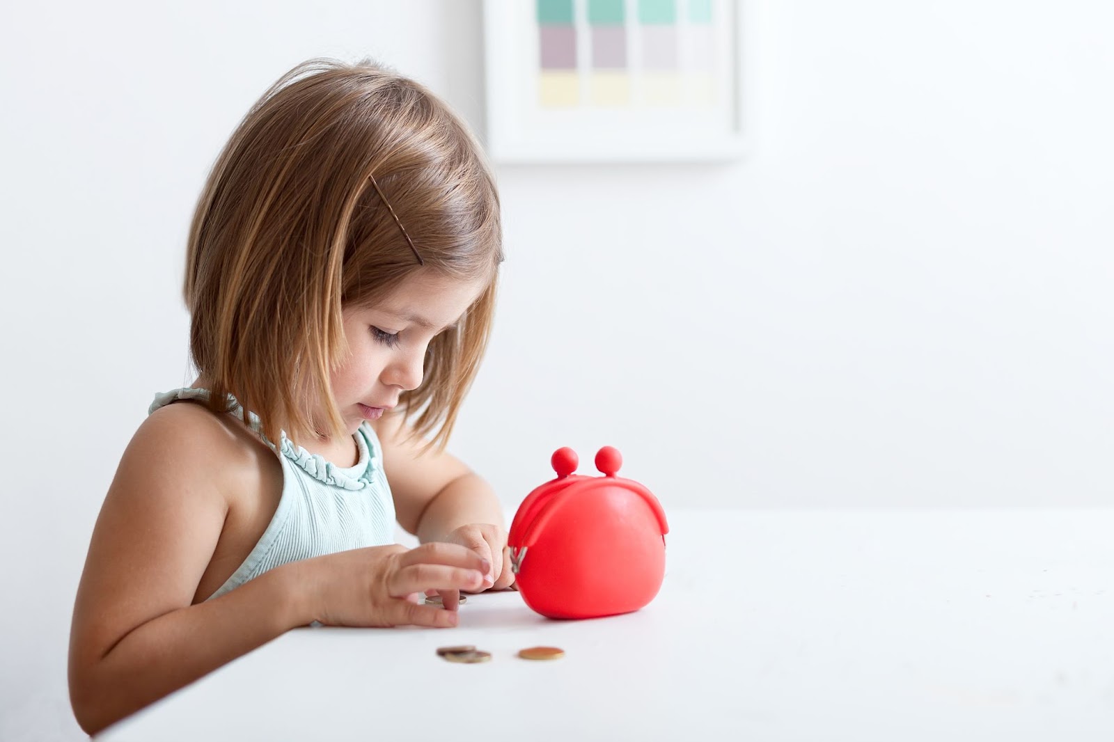 Bambine sedute a tavola a contare la paghetta