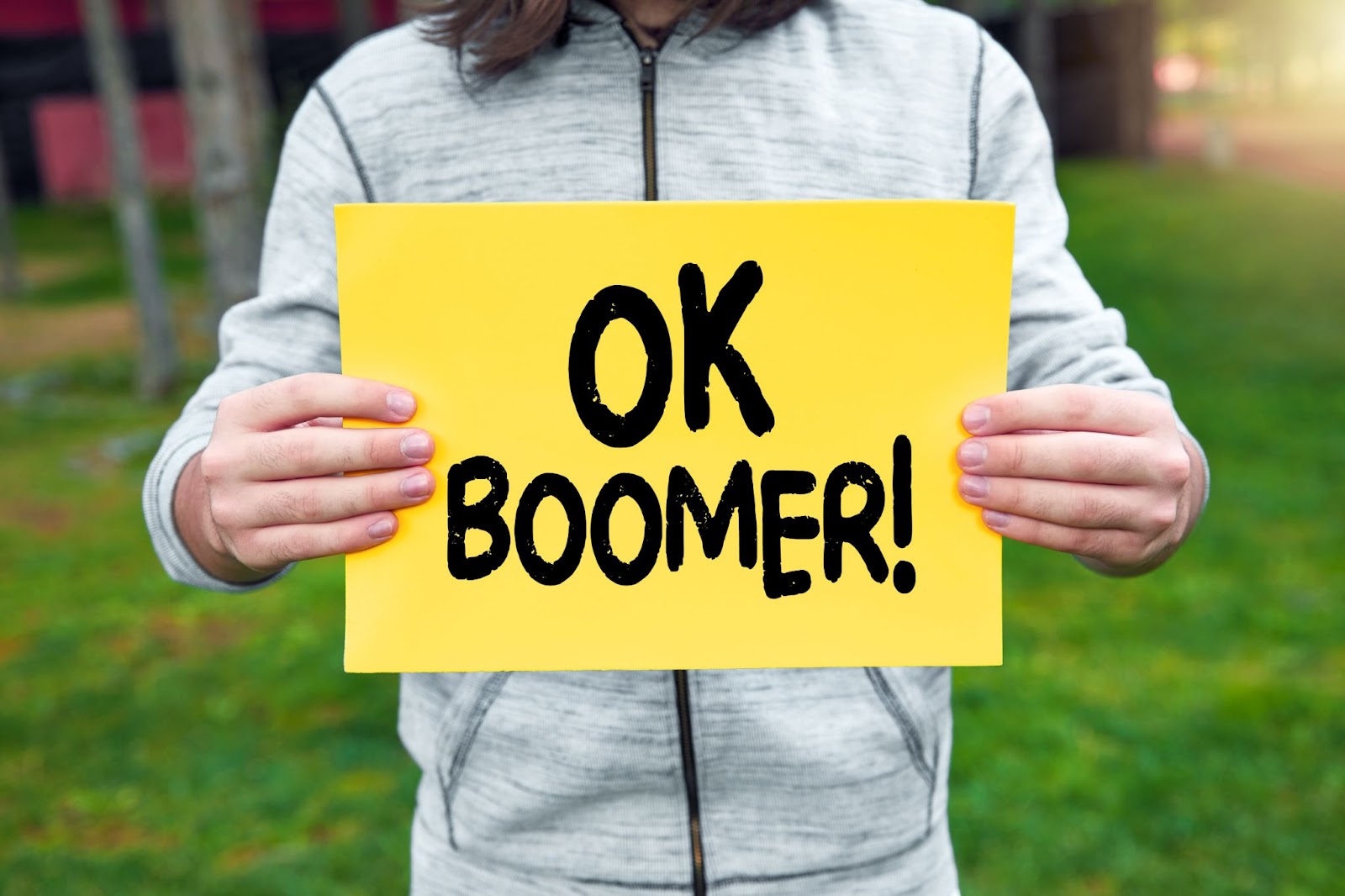 Un adolescente regge uno striscione con la parola ok boomer