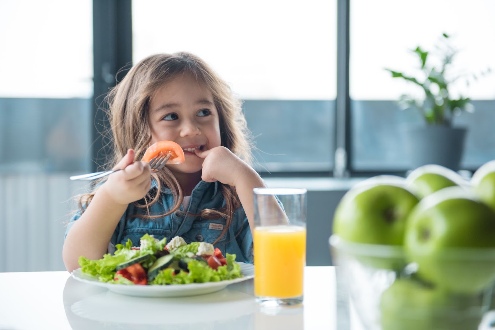 Ragazza allegra che mangia insalata