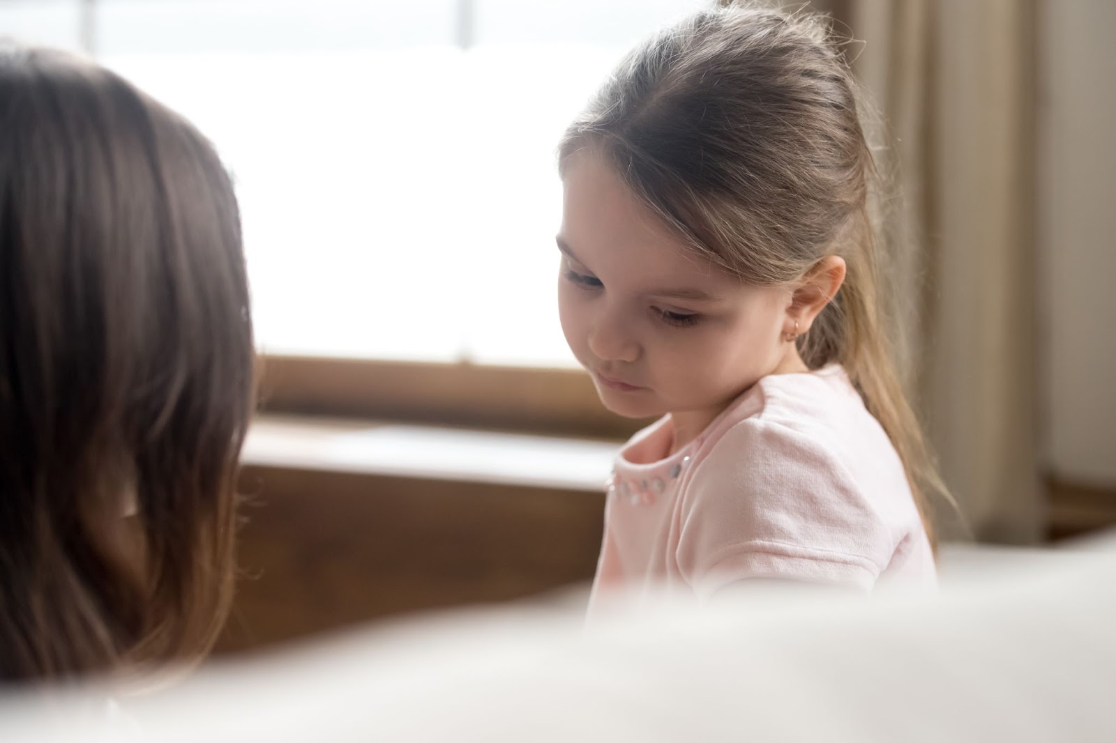Una timida bambina di sette anni parla con un genitore