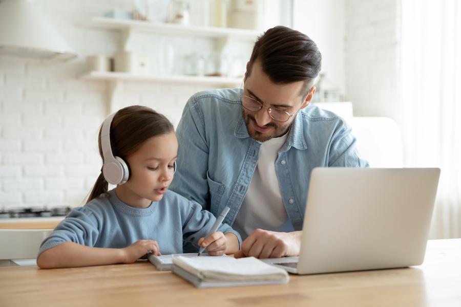 Giovane papà che aiuta la figlia a fare i compiti