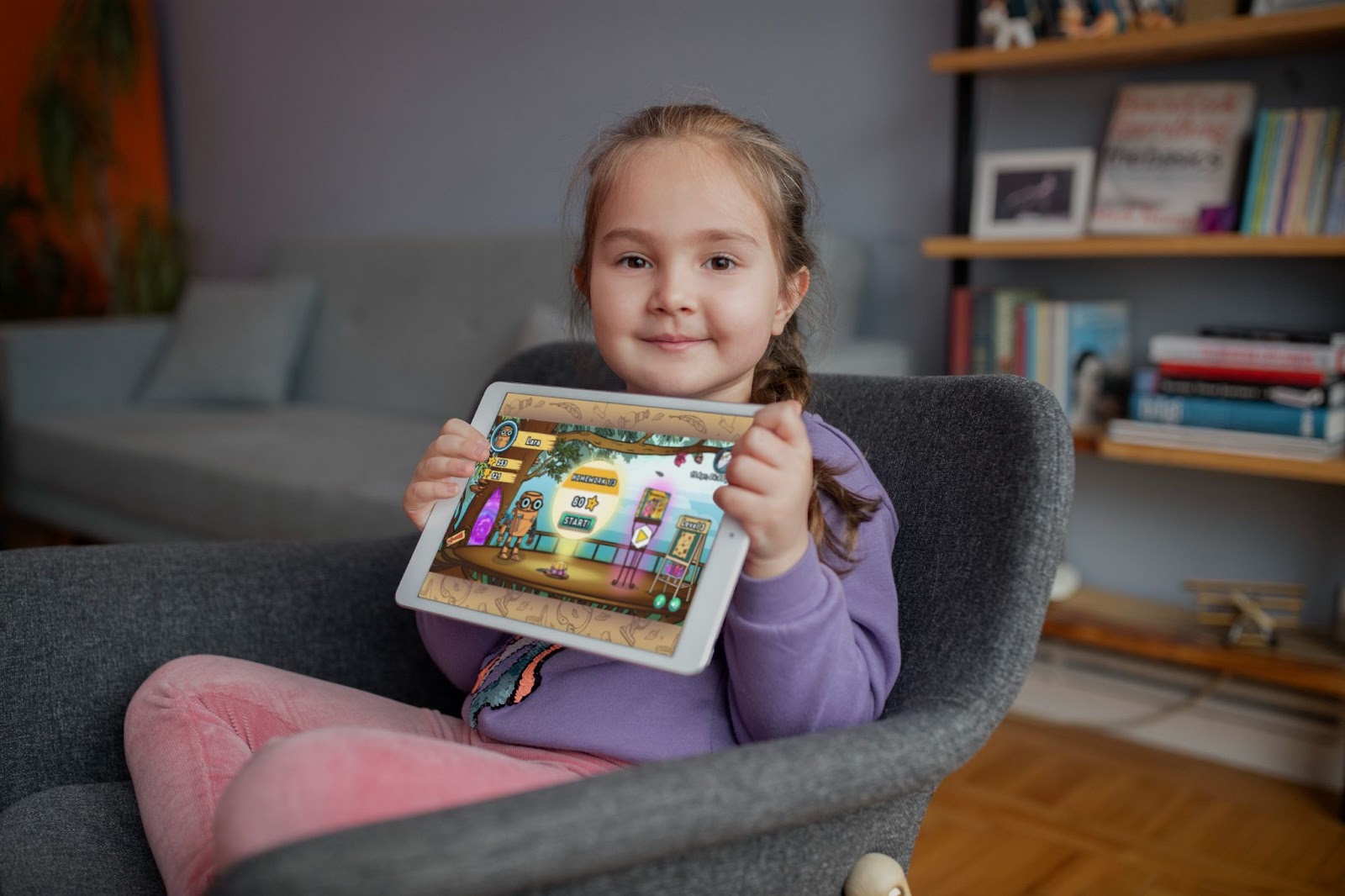 Una giovane ragazza con un tablet Novakid giochi online di scuola inglese
