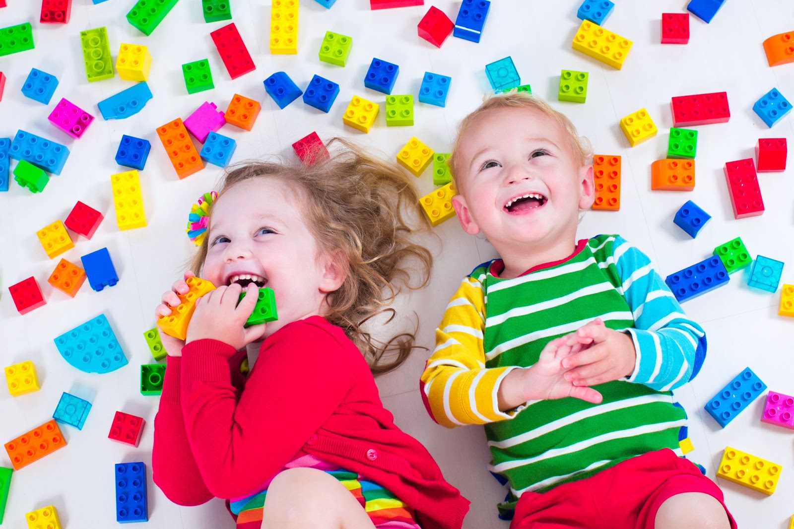 Un ragazzo e una ragazza giocano con giocattoli colorati